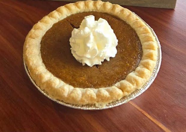 A small pumpkin pie with whipped cream